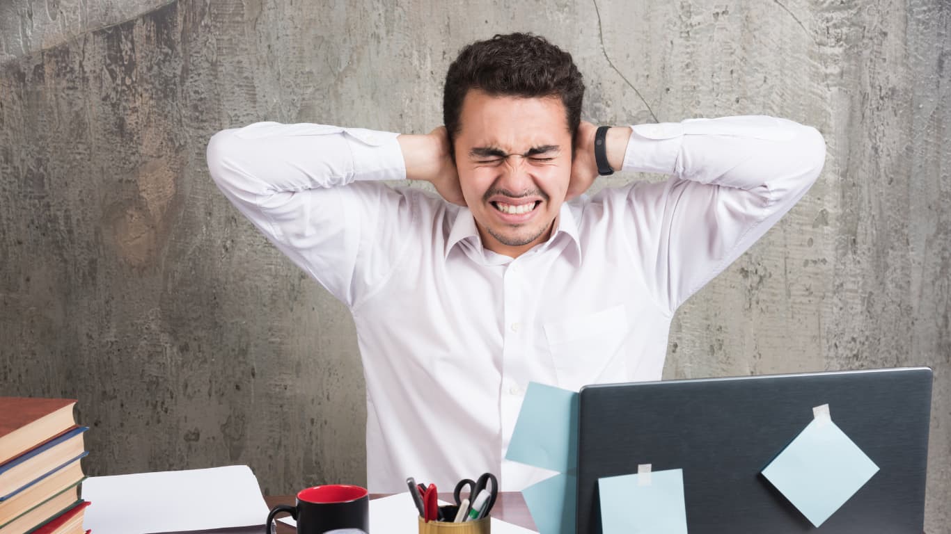 hombre estresado frente a computadora de trabajo