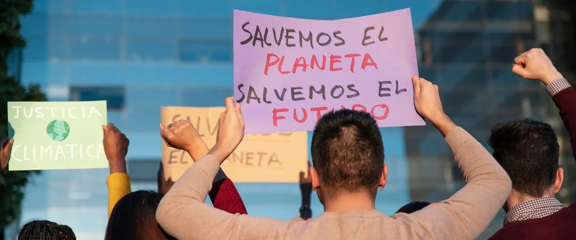 Un grupo de personas participando en una protesta, sosteniendo carteles que dicen 'Salvemos el planeta' y 'Salvemos el futuro'.