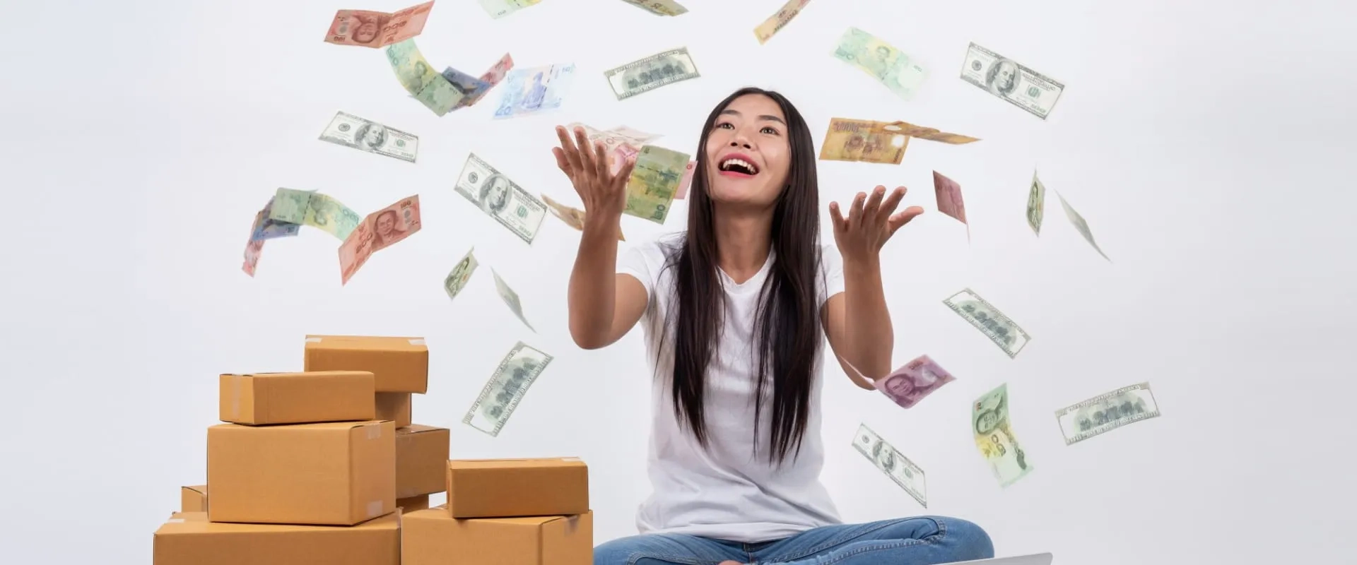 Una mujer sonriente está sentada en el suelo rodeada de cajas de cartón, mientras billetes de dinero caen a su alrededor. Ella levanta las manos con alegría, reflejando una sensación de éxito y celebración.