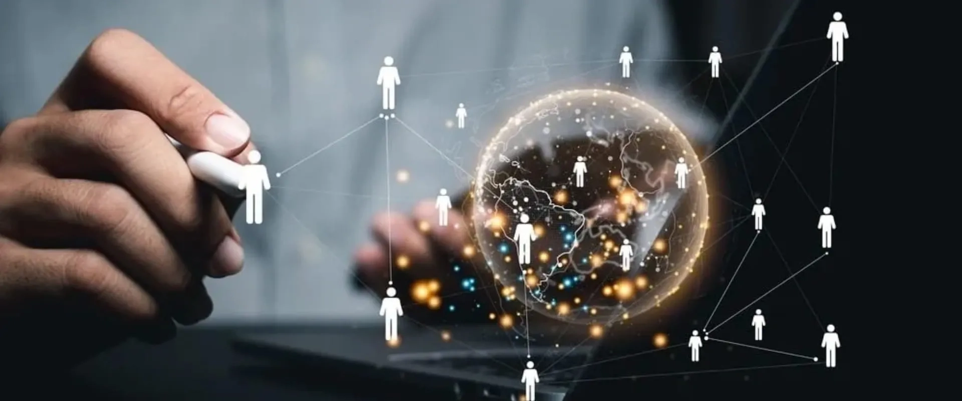 Una mano sostiene un lápiz mientras se conecta con una representación digital de un globo terráqueo, rodeado de íconos de personas y líneas que sugieren una red global. 